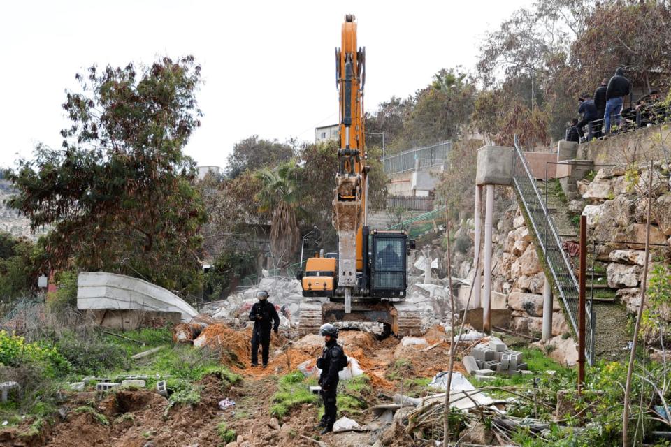 <div class="inline-image__caption"><p>Israeli security forces stand guard near a bulldozer after Israeli police demolished structures in Jabal Al-Mukaber in East Jerusalem, Feb. 13, 2023.</p></div> <div class="inline-image__credit">Ammar Awad/Reuters</div>