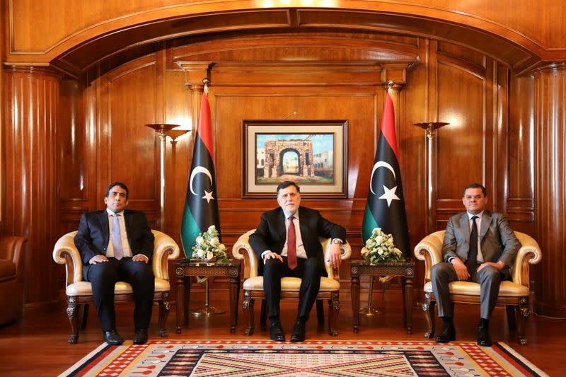 Libya's Prime Minister Abdulhamid Dbeibeh, Libya's internationally recognized former Prime Minister Fayez al-Sarraj, and Mohammed al-Menfi, Head of the Presidency Council, pose for a photo ahead of the handover ceremony in Tripoli