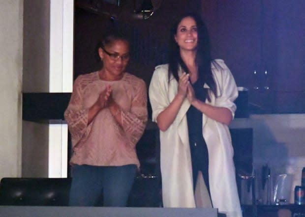 <p>Here's Meghan at the Invictus Games alongside her mother Doria Ragland. We're a fan of this silky oversized white coat's casual drama!</p>