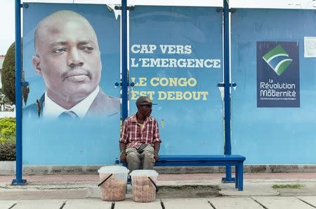 A vendor sits at a bus stand with pictures of Democratic Republic of Congo's President Joseph Kabila in Kinshasa, December 31, 2016. REUTERS/Robert Carrubba/Files