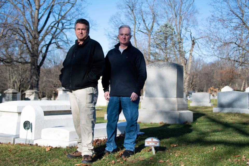 Christopher McMullin, left, and Tom McAndrew pose for a portrait at Doylestown Cemetery near the grave of an unknown man whose remains were found in the Neshaminy Creek in Bensalem in 2003 on Friday, Dec. 9, 2022.