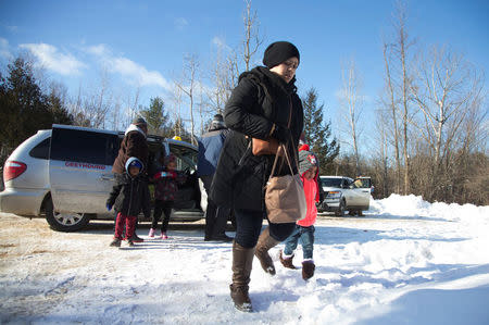 A family that claimed to be from Sudan leaves a taxi to walk across the U.S.-Canada border into Hemmingford, Canada, from Champlain in New York, U.S., February 17, 2017. REUTERS/Christinne Muschi