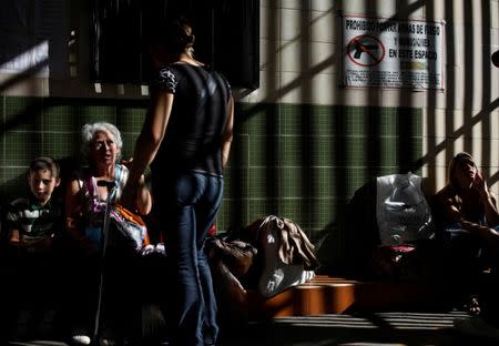 Josmer Rivas (L) eats a Venezuelan arepa for breakfast as he and his family wait for the bus to travel from Caracas to Ecuador at the Rutas de America's bus station in Caracas, Venezuela, November 3, 2017. Protests about land reform in Colombia led to the Pan-American highway being blocked so the bus was cancelled that day and Rivas left a few days later. REUTERS/Carlos Garcia Rawlins