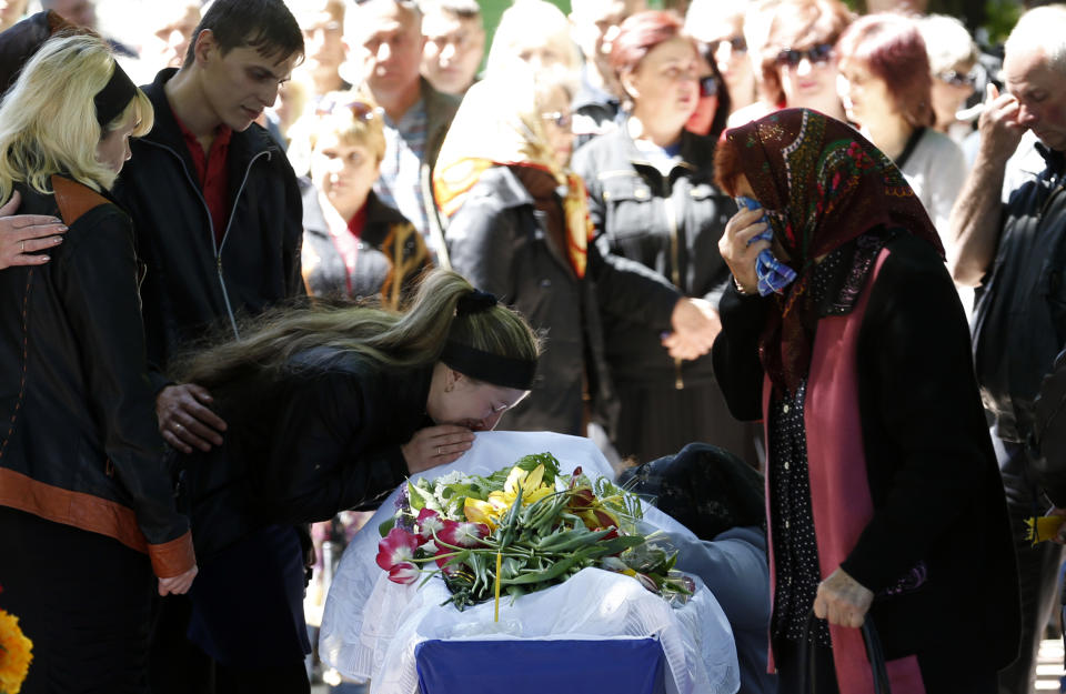 Relatives mourn in front of the casket of a person killed during last week's operation, during a commemorative service in the center of Slovyansk, eastern Ukraine, Wednesday, May 7, 2014. The U.S. and European nations have increased diplomatic efforts ahead of Ukraine's May 25 presidential election, as a pro-Russian insurgency continues to rock the country's eastern regions. (AP Photo/Darko Vojinovic)