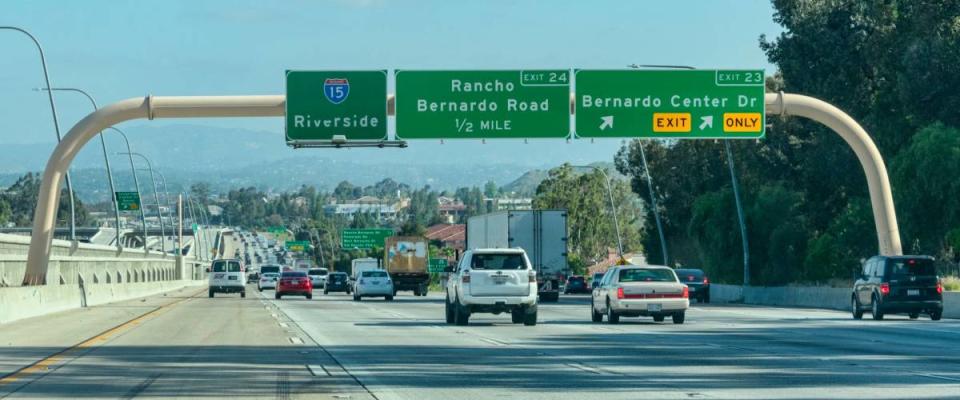 Guide signs on large overhead signage informing drivers about the intersections and highways, and distance and directions to destinations - Riverside, California, USA - April 22, 2019