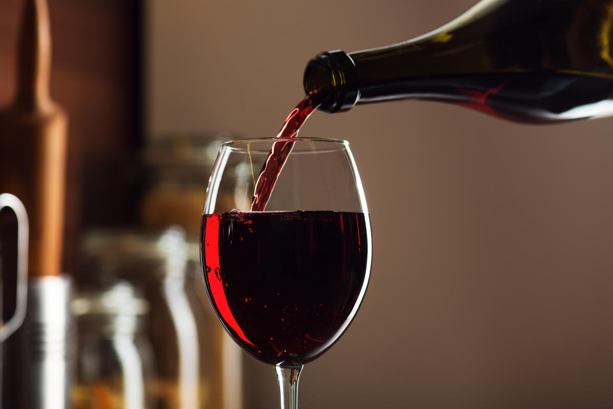 Wine glass being filled from bottle.