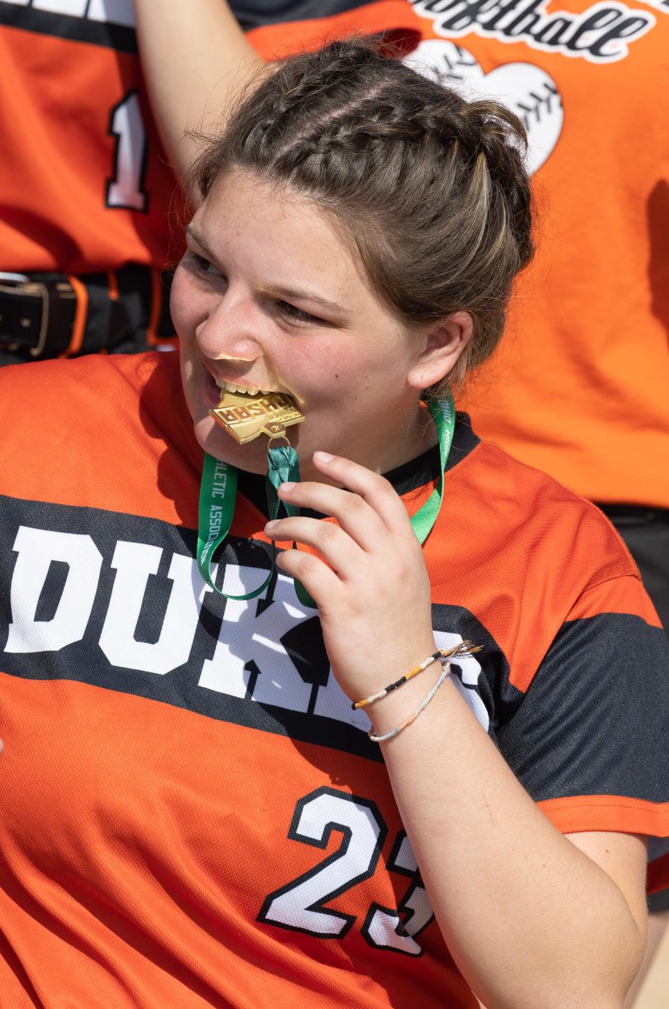 Marlington pitcher Sofia Nase bites down on her Division II district championship medal after beating Aurora, Thursday, May 18, 2023, in Jefferson.