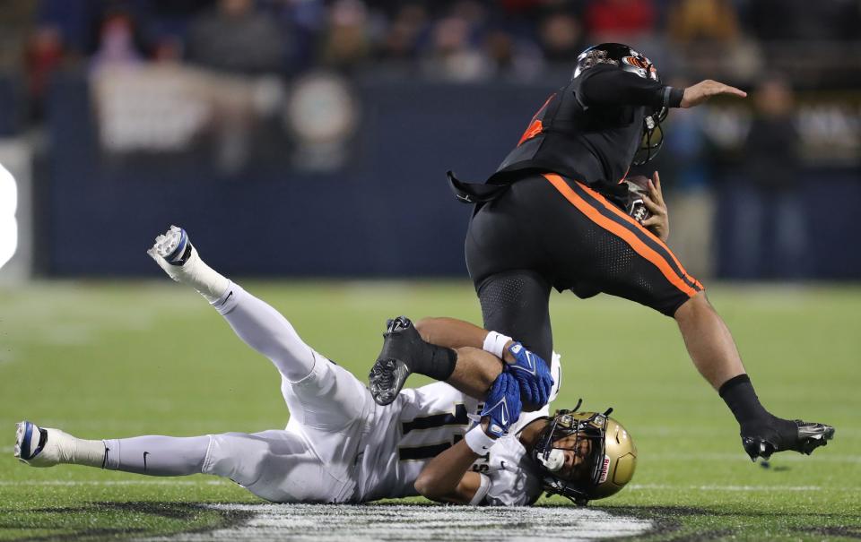 Hoban defensive back Elbert Hill IV, bottom, brings down Massillon quarterback DaOne Owens during the first half Thursday.