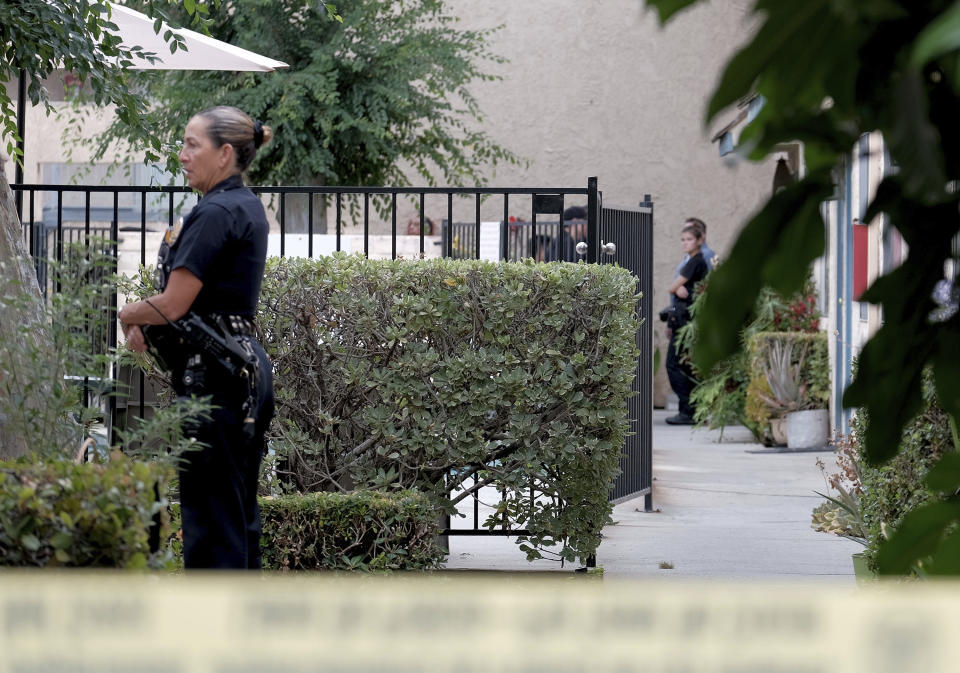 Los Angeles police officers guard an apartment where a shooting occurred in the Canoga Park area of Los Angeles on Thursday, July 25, 2019. Police say a gunman shot five people, killing three, in two attacks in Los Angeles before he tried to rob someone outside a bank. (Dean Musgrove/The Orange County Register via AP)