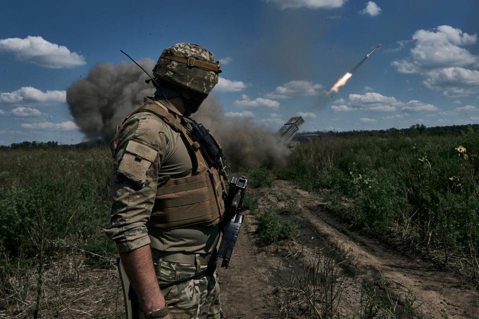 A Ukrainian soldier watches a Grad multiple launch rocket system firing shells with flyers near Bakhmut, Donetsk region (AP)