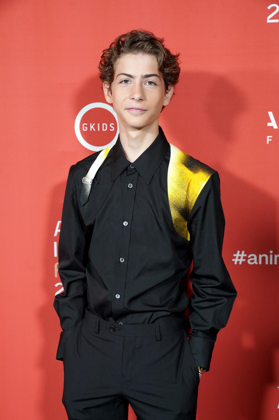 Jacob posing for photographers at a red carpet event with his hands in his pockets