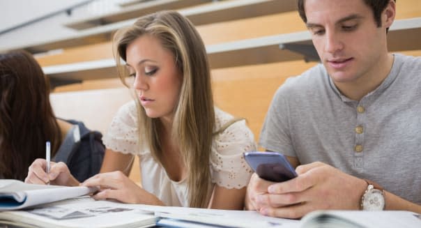 Student using smartphone in lecture hall