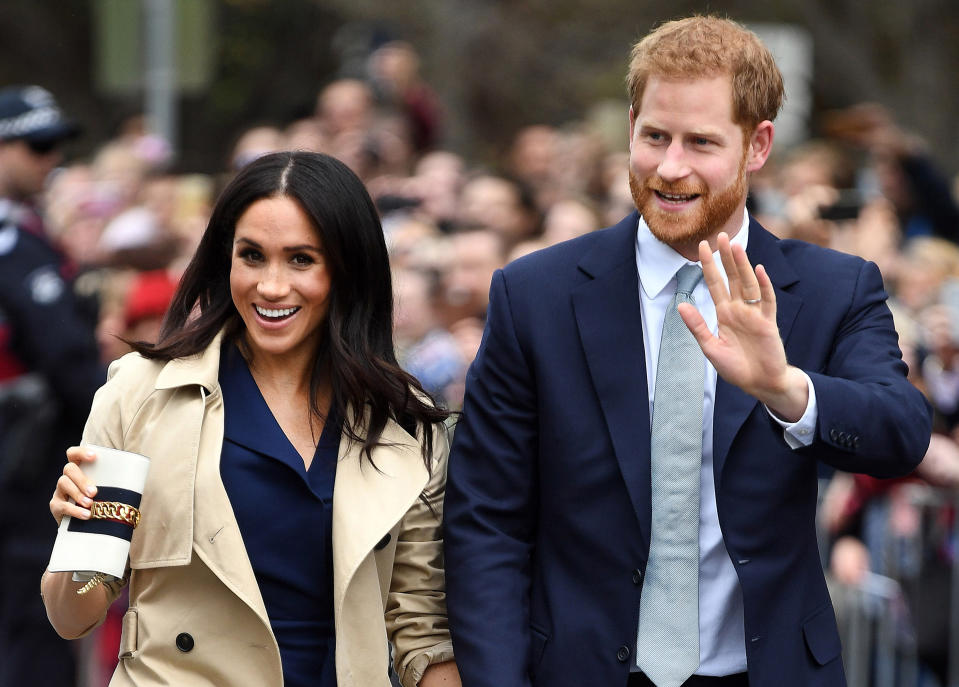 During a walkabout in Melbourne, Australia, Prince Harry cupped both of wife Meghan Markle’s hands — a new trend the internet has dubbed “super PDA.” (Photo: Andrew Parsons/i-Images)