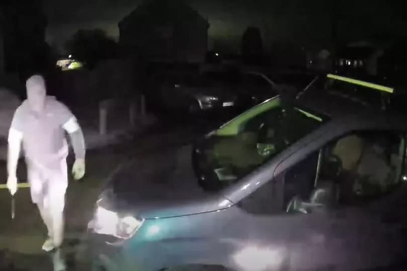 Man with machete and car in background