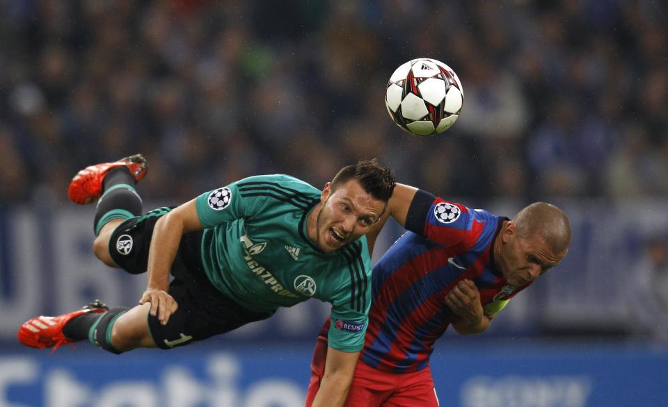 Steaua Bukarest's Alexandru Bourceanu and Schalke 04's Marco Hoeger (L) head the ball during their Champions League group E soccer match in Gelsenkirchen September 18, 2013. REUTERS/Ina Fassbender (GERMANY - Tags: SPORT SOCCER TPX IMAGES OF THE DAY)