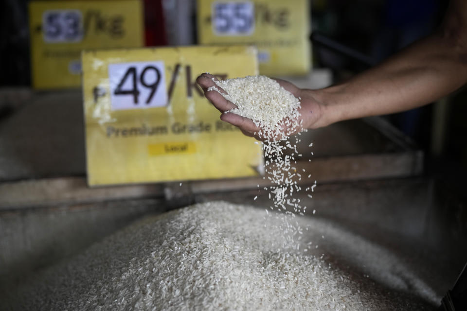 A man checks rice at a store in Quezon city, Philippines, on Monday, Aug. 14, 2023. Countries worldwide are scrambling to secure rice after a partial ban on exports by India cut supplies by roughly a fifth. (AP Photo/Aaron Favila)