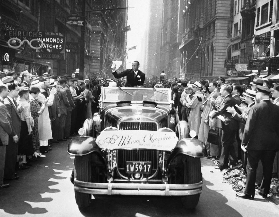 Broadway was a snowstorm canyon as proud Manhattanites feted returned U.S. Olympic stars with a fleecy ticker tape parade in New York on Sept. 3, 1936. The fellow with the broad grin in the foreground is Jesse Owens, who won three gold medals and helped other athletes win another for the U.S. (AP Photo)