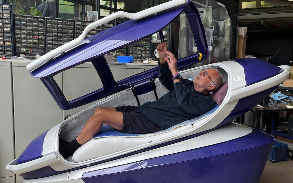 Dr. Nitschke lies in the open pod and demonstrates how it can be closed from the inside by pulling on a strap