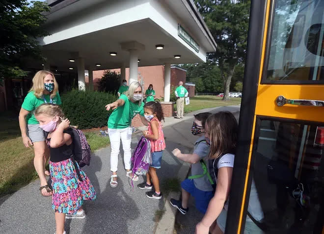 Staff members at the Martinson Elementary School in Marshfield direct students to the school entrance during the first day of school on Aug. 31, 2021.