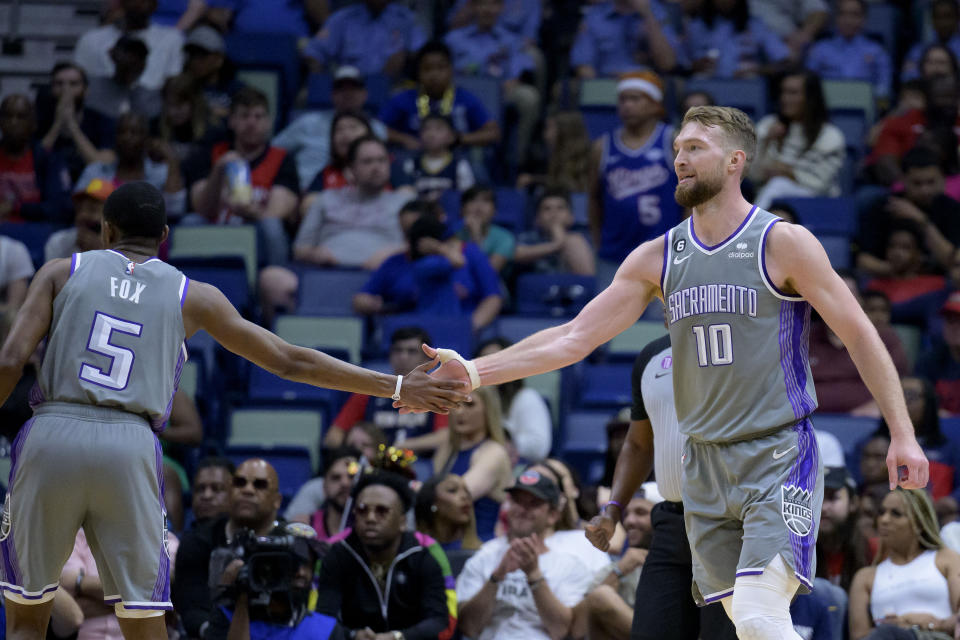 Sacramento Kings forward Domantas Sabonis (10) celebrates with guard De'Aaron Fox (5) after scoring and being fouled during the first half of the team's NBA basketball game against the New Orleans Pelicans in New Orleans, Tuesday, April 4, 2023. (AP Photo/Matthew Hinton)