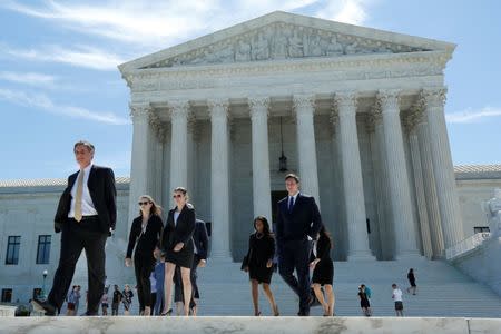 FILE PHOTO: People walk out after the U.S. Supreme Court granted parts of the Trump administration's emergency request to put his travel ban into effect immediately while the legal battle continues, in Washington, U.S., June 26, 2017. REUTERS/Yuri Gripas/File Photo