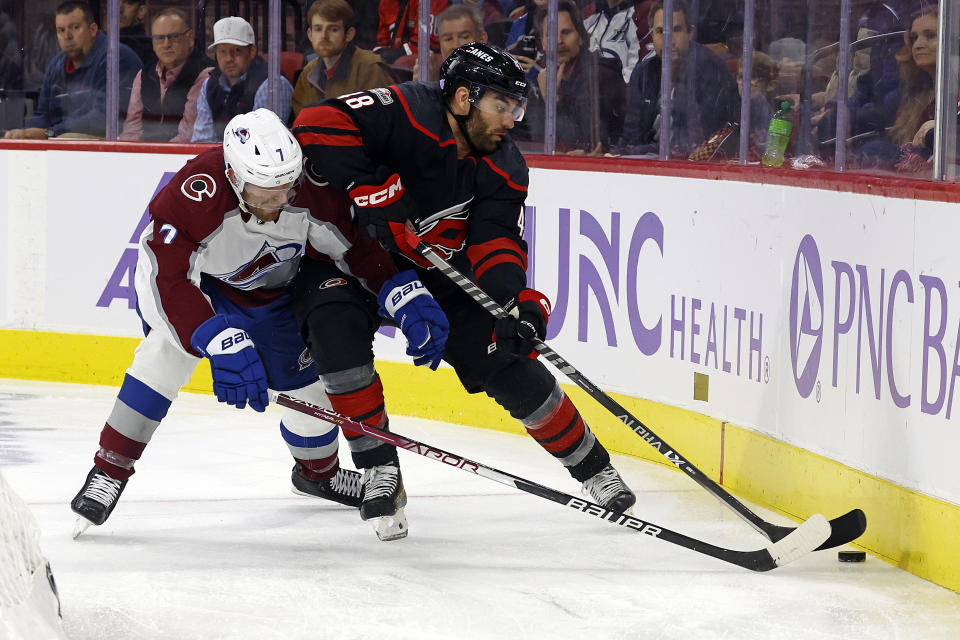Carolina Hurricanes' Jordan Martinook (48) battles for the puck with Colorado Avalanche's Devon Toews (7) during the second period of an NHL hockey game in Raleigh, N.C., Thursday, Nov. 17, 2022. (AP Photo/Karl B DeBlaker)