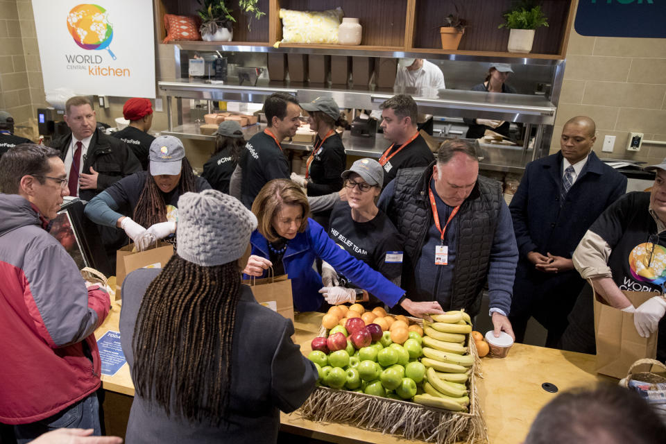 House Speaker Nancy Pelosi of Calif., center left, and Chef Jose Andres, second from right, help give out food at World Central Kitchen, the not-for-profit organization started by Chef Jose Andres, Tuesday, Jan. 22, 2019, in Washington. The organization devoted to providing meals in the wake of natural disasters, has set up a distribution center just blocks from the U.S. Capitol building to assist those affected by the government shutdown. (AP Photo/Andrew Harnik)