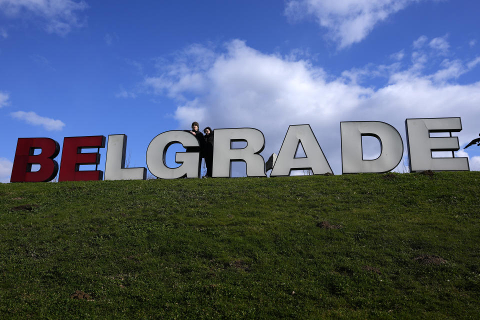 Mariia Vyhivska, from Ukraine, right, and Iurii Kurochkin, from Russia, pose next to a sign reading "Belgrade", in Belgrade, Serbia, Sunday, Feb. 5, 2023. Vyhivska and Kurochkin fell in love before Russia invaded Ukraine, while playing an online video game. To get together, they had to leave their homes and defy hatred generated by war. An estimated 200,000 Russians and some 20,000 Ukrainians have come to Serbia in the past year. (AP Photo/Darko Vojinovic)