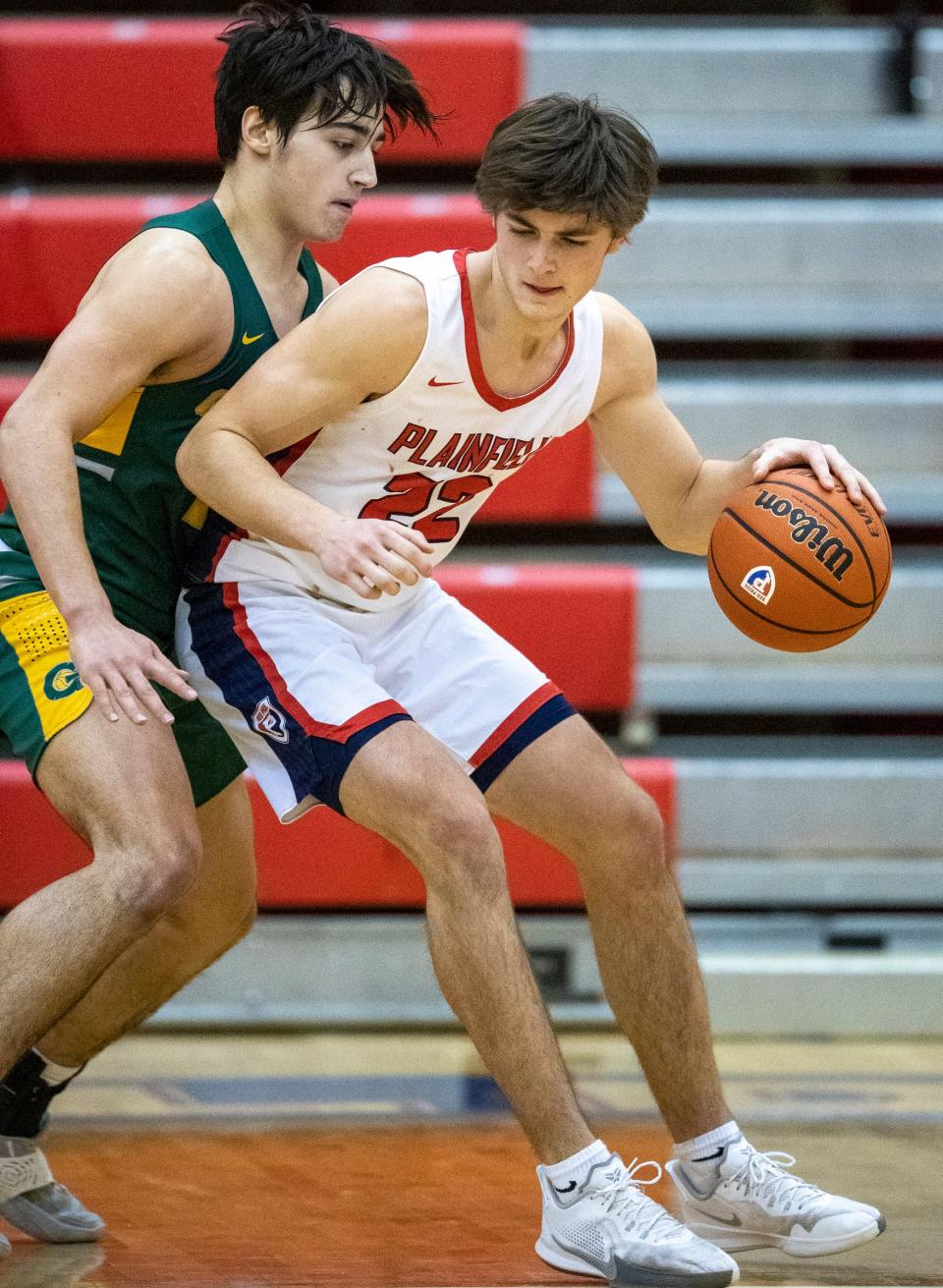 Greenwood High School's Noah Apgar (11) defends Plainfield High School's Cael Vanderbush (22), Friday, Feb 12, 2021, during boys basketball game action between Greenwood at Plainfield High School. Plainfield won 44-30. 