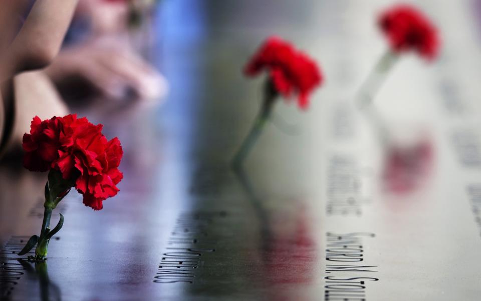 Carnations are left on names inscribed into the North Pool during 9/11 Memorial ceremonies marking the 12th anniversary of the 9/11 attacks on the World Trade Center in New York on September 11, 2013. (REUTERS/Adrees Latif)