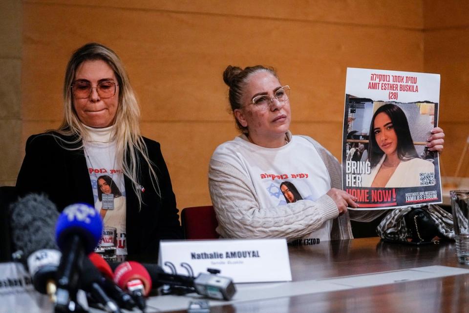 Alin Atias, right, holds a picture of her daughter Amit Buskila (AP)