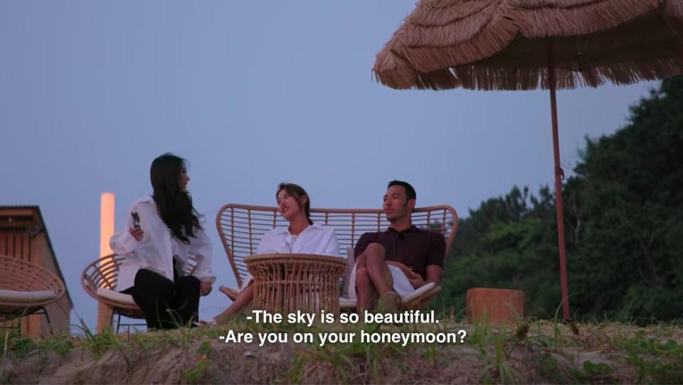 Jin-taek and So-yeon sit on a bench together watching the sunset, So-yeon says the sky is so beautiful and Yea-won says "Are you on your honeymoon?"