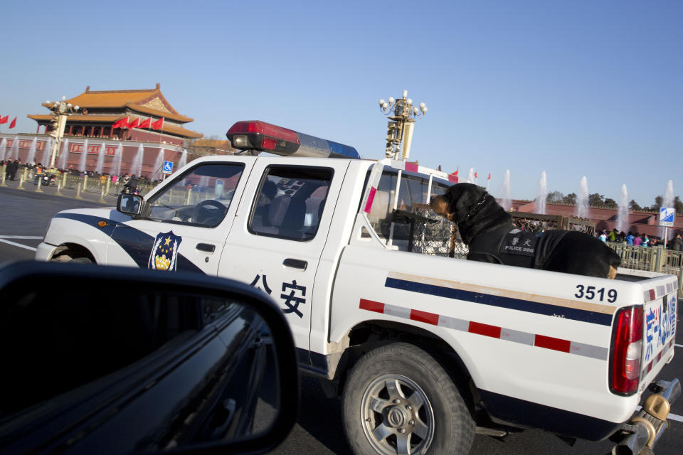 A police dog is transported on a police truck past Tiananmen Gate near the Great Hall of the People where sessions of the National People's Congress and Chinese People's Political Consultative Conference are held in Beijing, China, Tuesday, March 4, 2014. (AP Photo/Ng Han Guan)