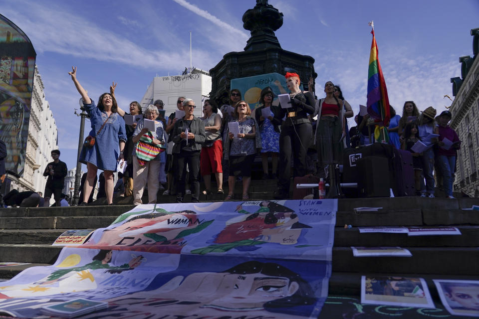 Demonstrators gather in Piccadilly Circus, in London, Saturday, Sept. 16, 2023, as today marks the anniversary of the death of Mahsa Amini in Iran. (AP Photo/Alberto Pezzali)