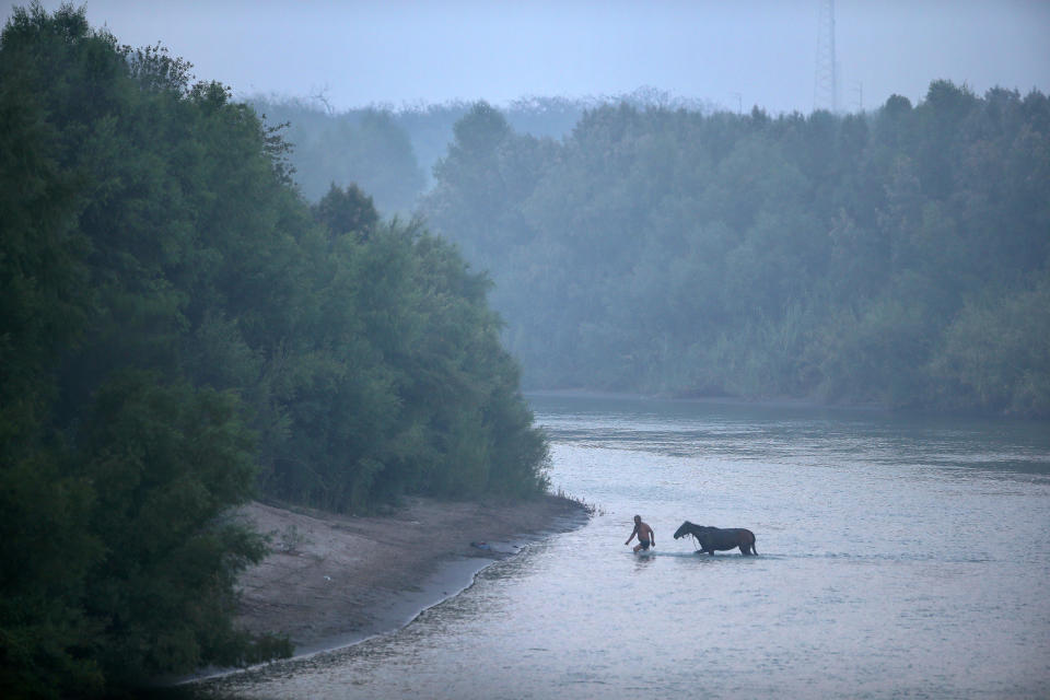 <p>A man returns to the Mexican side of the border after washing his horse in the Rio Grande at the U.S.-Mexico border at dusk on July 24, 2014, near Mission, Texas. Tens of thousands of immigrants — many of them families or unaccompanied minors — crossed illegally into the U.S. that year and presented themselves to federal agents, causing a humanitarian crisis on the U.S.-Mexico border. Texas’s Rio Grande Valley became the epicenter of the crisis as more immigrants, especially Central Americans, crossed illegally from Mexico into that area than any other stretch of the America’s 1,933-mile border with Mexico. (Photo: John Moore/Getty Images) </p>