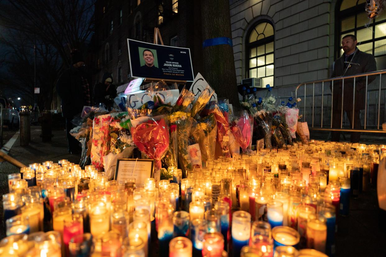 Police officers, clergy and community members hold a candlelight vigil at the NYPD 32nd precinct on January 24, 2022 in the Harlem neighborhood of New York City.