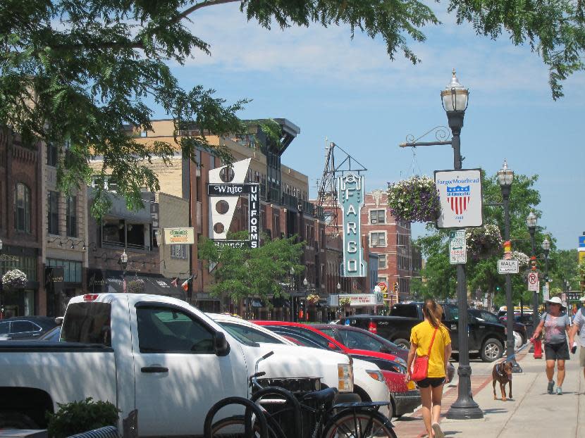 This July 17, 2013 photo shows pedestrians walking along Broadway in downtown Fargo, N.D. With just over 100,000 people, this city on the eastern edge of the state offers local culture with a good dose of pride and quirkiness. (AP Photo/Coralie Carlson)