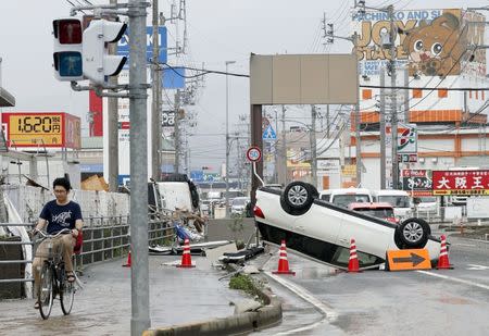 An overturned car remains on a street after heavy rain in Ozu, Ehime Prefecture, Japan, in this photo taken by Kyodo July 8, 2018. Mandatory credit Kyodo/via REUTERS