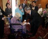 Octogenarian Phyllis Lyon (standing, 2nd L) watches as her partner Del Martin (bottom) signs their gay-marriage certificate in front of San Francisco county clerk Edwin Lee during the first legal same-sex marriage ceremony at San Francisco City Hall in San Francisco, California June 16, 2008. California performed its first legally recognized same-sex weddings and opened its doors to gay and lesbian couples from around the country, a move likely to challenge other states that define marriage as between a man and a woman. The ceremony was presided over by Mayor Gavin Newsom (back, 3rd L).