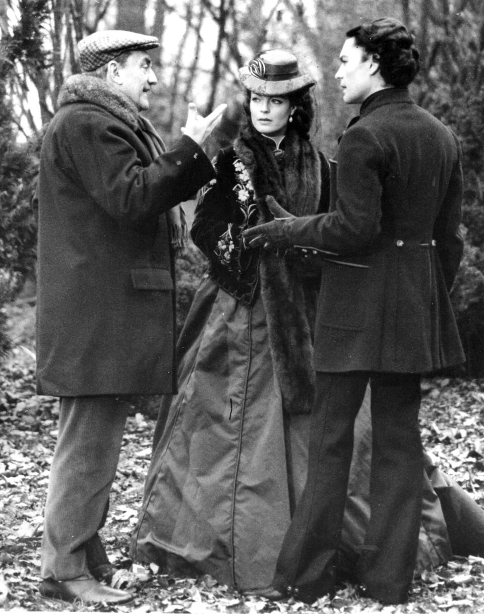 FILE -Italian movie director Luchino Visconti, left, gives last instructions to actor Helmut Berger and actress Romy Schneider before filming a scene of 'Ludwig' at a location near Munich, Germany, April 15, 1972. Austrian-born actor Helmut Berger, a European movie star in the 1960s and 1970s who rose to prominence with roles in films by Italian director Luchino Visconti, has died. He was 78. (AP Photo/Str, File)