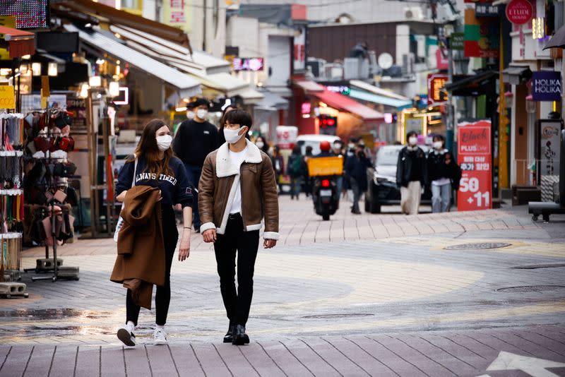 Pedestrians wearing masks walk on a shopping street amid the coronavirus disease (COVID-19) pandemic in Seoul