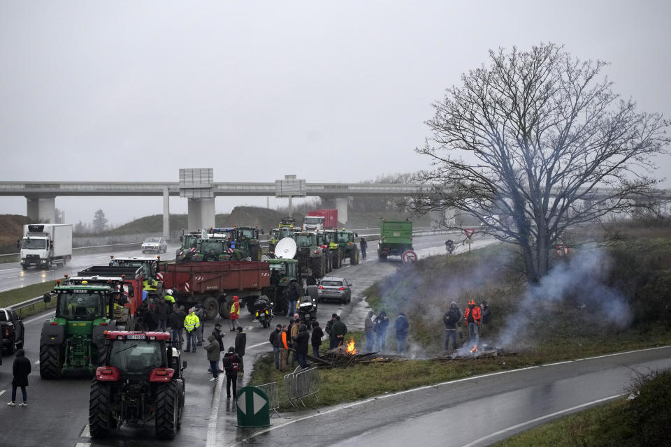 Farmers block a highway leading to Paris, Friday, Jan. 26, 2024 in Saclay, south of Paris. Snowballing protests by French farmers crept closer to Paris with tractors driving in convoys and blocking roads in many regions of the country to ratchet up pressure for government measures to protect the influential agricultural sector from foreign competition, red tape, rising costs and poverty-levels of pay for the worst-off producers. (AP Photo/Christophe Ena)