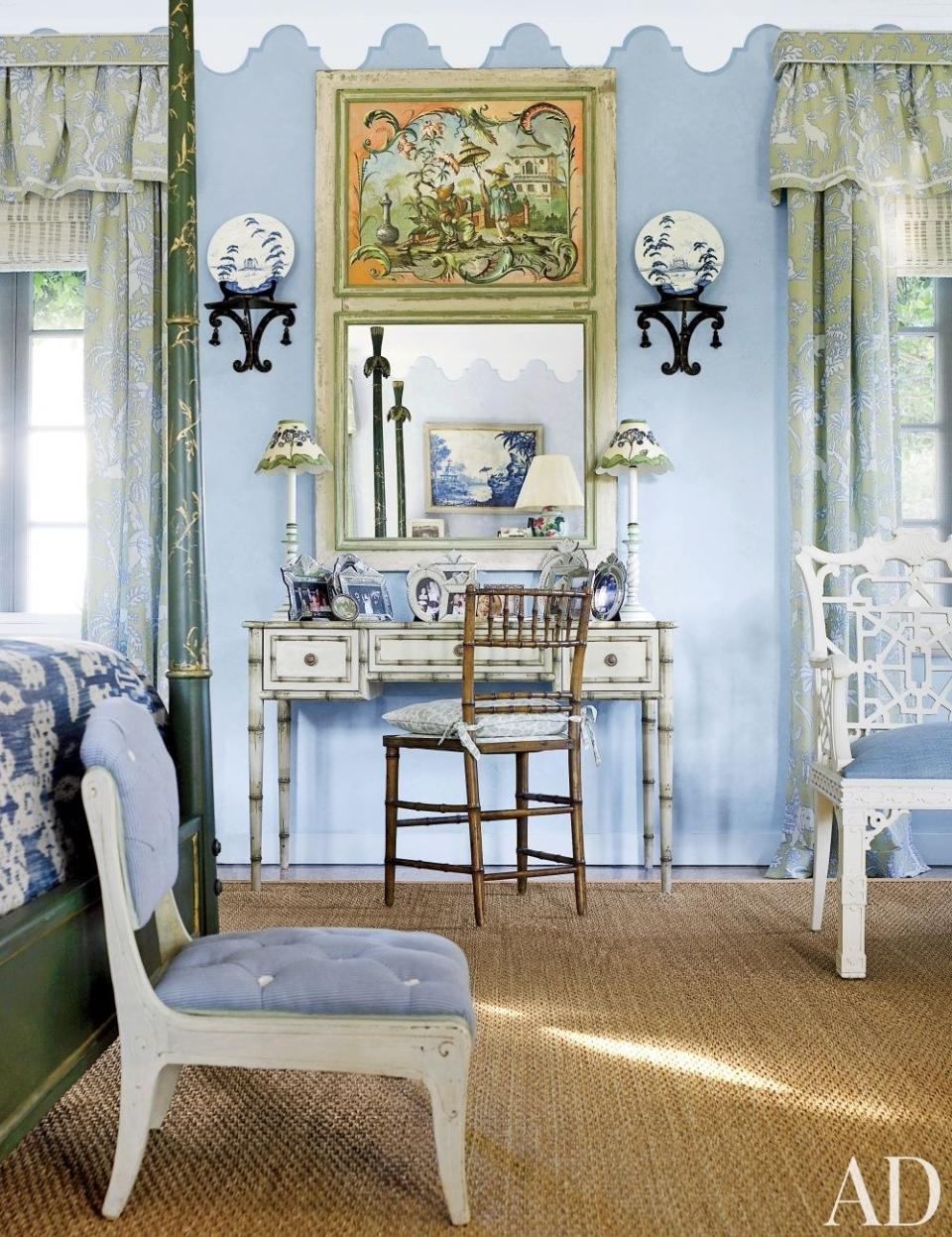 Painted furniture and a blue, white, and green palette freshen a <a rel="nofollow noopener" href="https://www.architecturaldigest.com/story/nancy-morton-boca-grande-florida-home-article?mbid=synd_yahoo_rss" target="_blank" data-ylk="slk:master bedroom in Florida;elm:context_link;itc:0;sec:content-canvas" class="link ">master bedroom in Florida</a>. Brackets from John Rosselli hang above a Louis J. Solomon faux-bamboo desk with custom-painted decoration by Bob Christian; the curtain fabric is by Brunschwig & Fils, a Clarence House stripe covers the slipper chair, and the sea-grass carpet is by Stark.