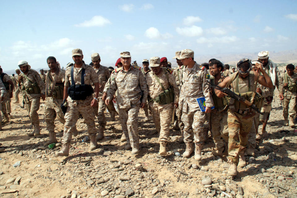 In this photo provided by Yemen's Defense Ministry, Yemeni Defense Minister Mohammad Nasser Ahmad, center left, inspects the troops at areas seized from al-Qaida in the southeastern province of Shabwa, Yemen, Thursday, May 8, 2014. Yemeni armed forces on Thursday swept al-Qaida fighters out of a district in the country's south, one of the main goals of the major offensive waged by the military the past two weeks, the Defense Ministry said, amid fears of retaliatory attacks which officials say prompted the closure of the US embassy in the capital as a precaution. (AP Photo/Yemen's Defense Ministry)