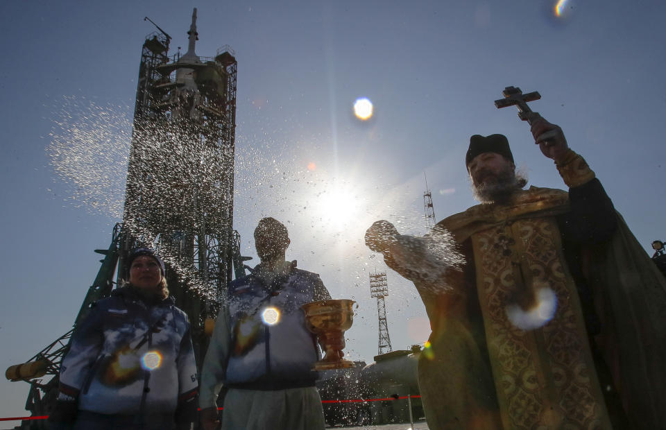 An Orthodox priest conducts a blessing service in front of the Soyuz FG rocket at the Russian leased Baikonur cosmodrome, Kazakhstan, Thursday, March 14, 2019. The new Soyuz mission to the International Space Station (ISS) is scheduled on Thursday, March 14 with U.S. astronauts Christina Hammock Koch, Nick Hague, and Russian cosmonaut Alexey Ovchinin. (AP Photo/Dmitri Lovetsky)