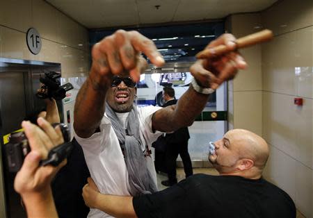 Former basketball star Dennis Rodman of the U.S. gestures as he talks to journalists chasing him upon his arrival at Beijing Capital International Airport September 7, 2013. REUTERS/Kim Kyung-Hoon