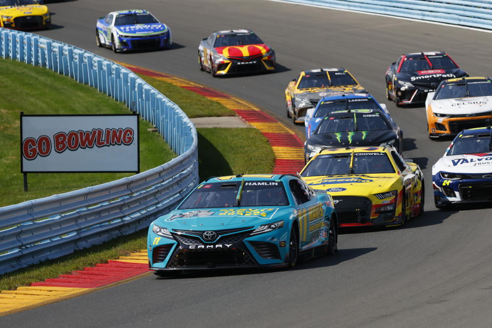 Denny Hamlin leads the pack during a NASCAR Cup Series auto race in Watkins Glen, N.Y., Sunday, Aug. 20, 2023. (AP Photo/Jeffrey T. Barnes)