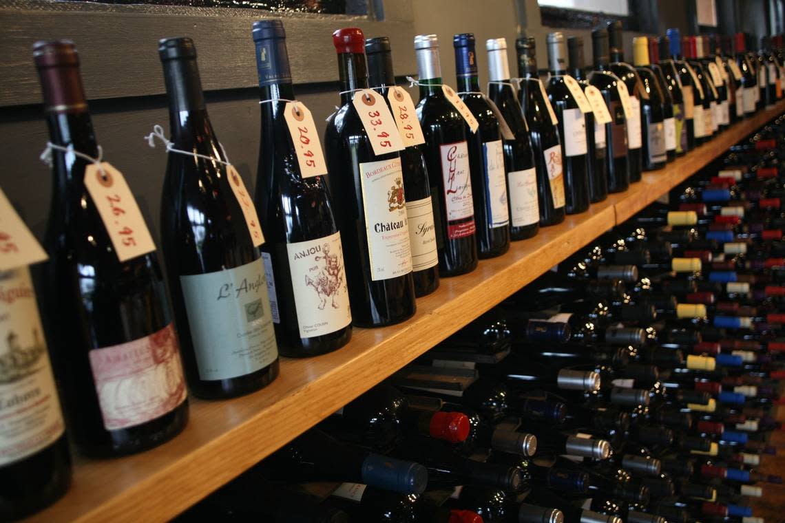 Racks of wine shown at the Wine + Market at 486 W. Second St. in Lexington, Ky. The wine shop, which also sells bourbon and gourmet foods, is closing at the end of the year.