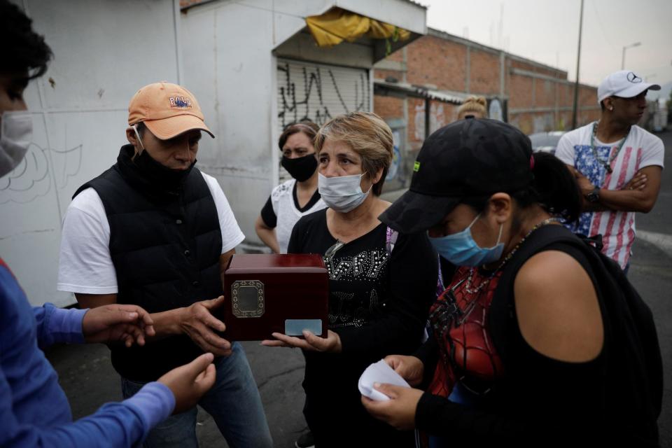 Family members hold an urn containing the remains of Lucia Escobar Paredes, 75, who died of the COVID-19 outside of Izaz crematorium, in Mexico City on April 22.