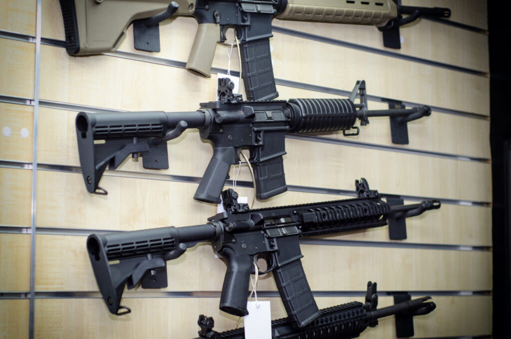 A gun rack with rifles is displayed at a weapons retailer.